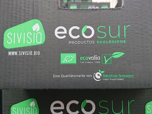 KI generiert: Das Bild zeigt die Aufschrift auf einer Verpackung mit Logos und Informationen zu ökologischen Produkten von "ecosur". Es enthält auch Hinweise auf Zertifizierungen wie "ecovalia" und die Firma "Naturkost Schramm".