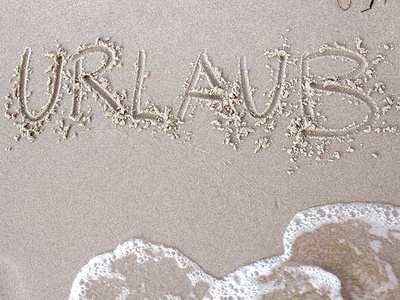 "Urlaub" in den Sand am Stand geschrieben