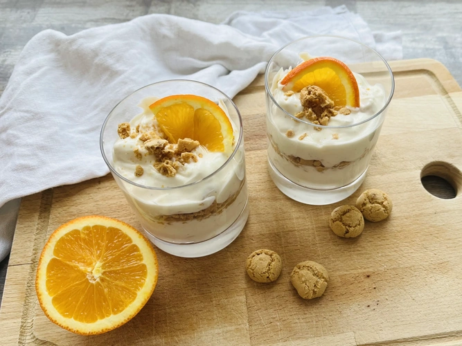 Zwei Dessertgläser mit Orangenquark und Amarettini