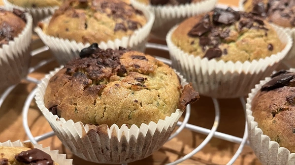 KI generiert: Muffins in Papierförmchen auf einem Abkühlgitter.