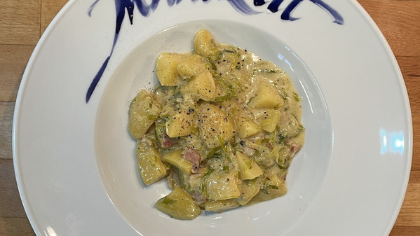 Cremige Kartoffel-Lauch-Pfanne auf weißem Teller