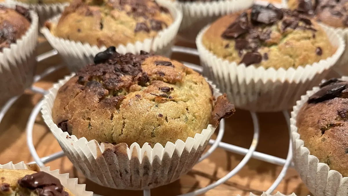 Zucchini Muffins mit Schokolade auf weißem Küchenrost