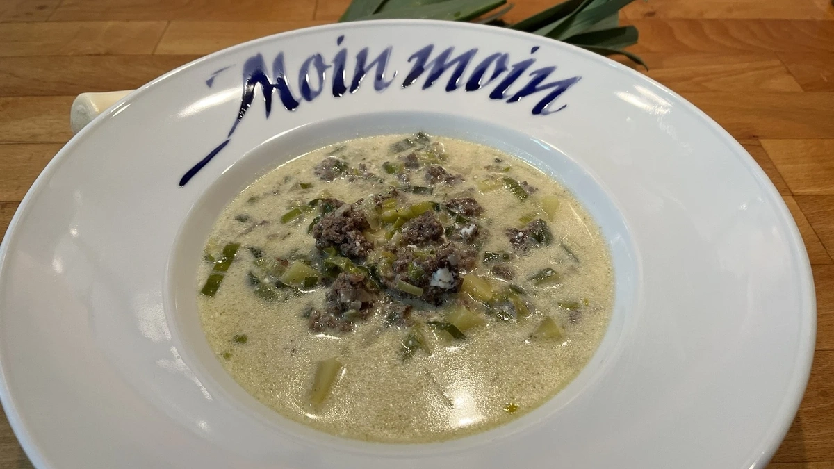 Käse-Lauch Suppe mit Hackfleisch auf weißem Teller mit der Aufschrift "Moin Mloin"