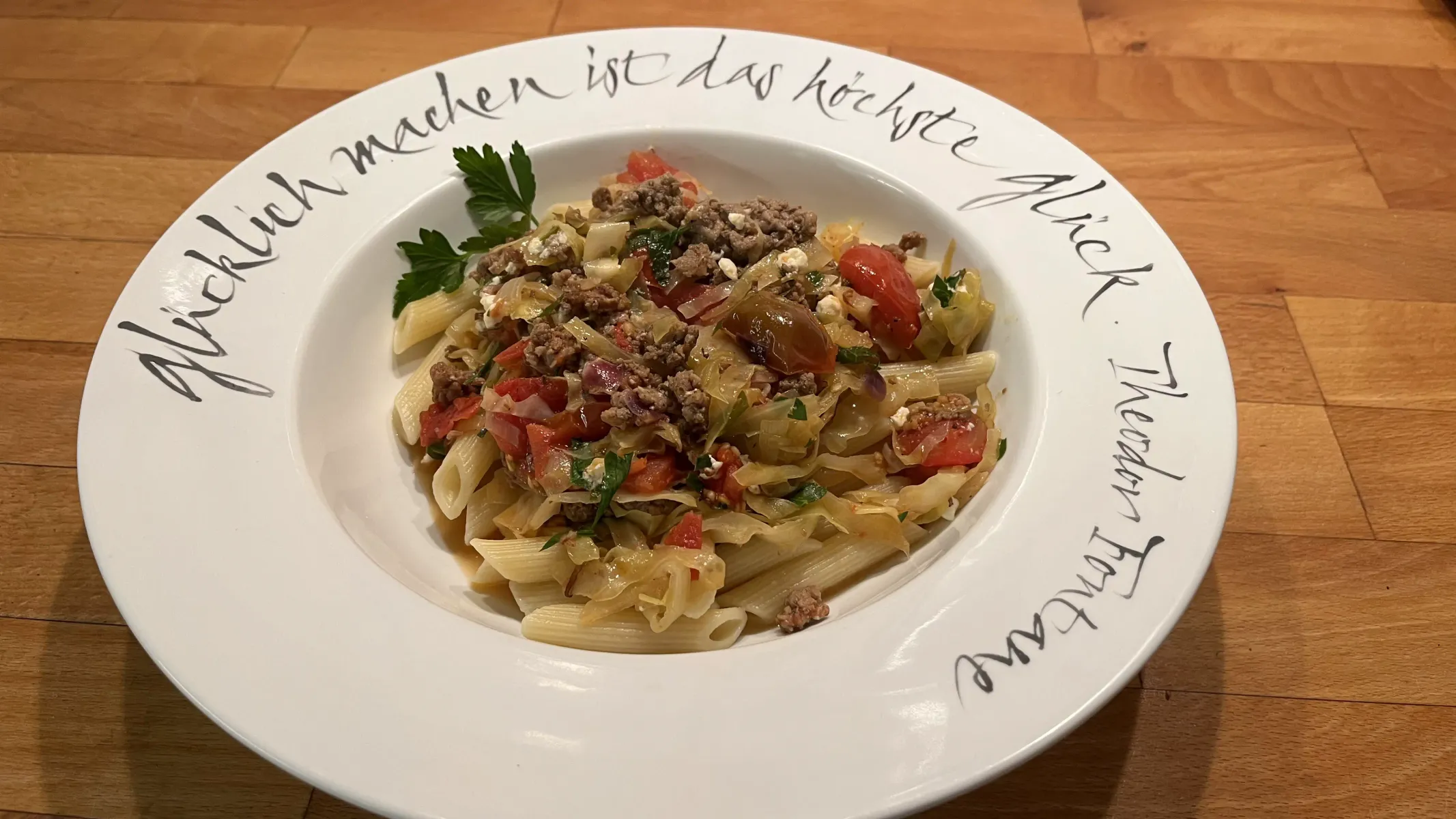 weißer Teller gefüllt mit Nudeln und Spitzkohl-Tomate-Hackfleisch