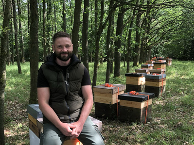 Hendrik Wenk mit Bienenstöcken im Wald