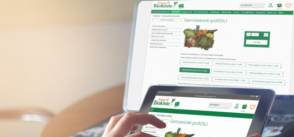 Hand zieht auf Tablet etwas auf | Im Hintergrund ein Laptop mit der gleichen Website